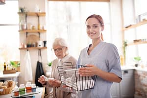 Caregiver And Client With Medications In Kitchen