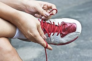 person tying red shoelaces