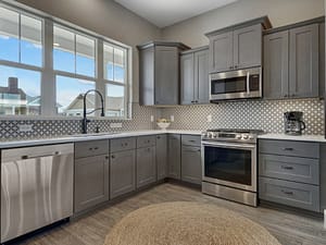 Corner view of modern kitchen with gray cabinets