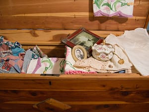 Open cedar chest with linens and mementos inside