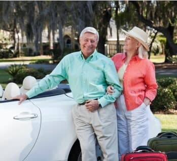 Afluent older couple in front of convertable care