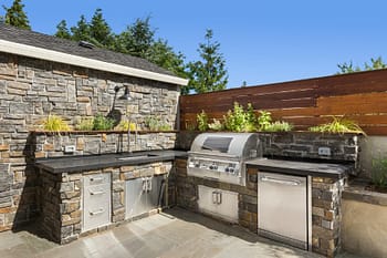 Stone outdoor kitchen with sink and grill
