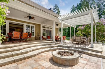 Outdoor patio with fire pit and outdoor dining table under pergola 