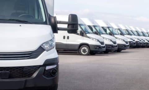 A fleet of white delivery vans