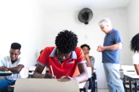 A student is taking a test in a classroom.