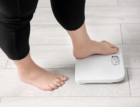 Woman Weighing Herself On Scale