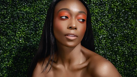 black woman with orange eye make up headshot