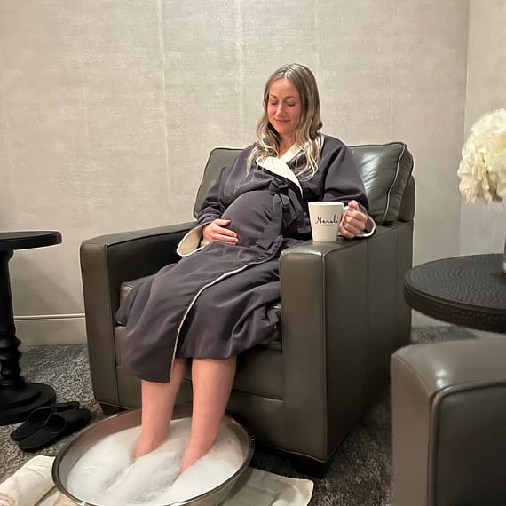 Pregnant woman experiencing a relaxing foot soak at spa