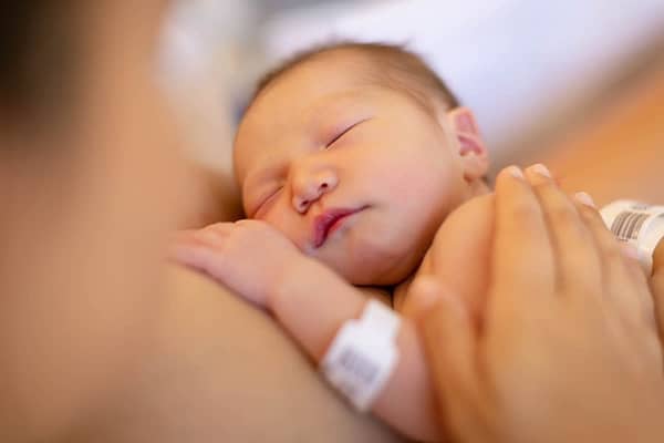 A Newborn Baby Being Held