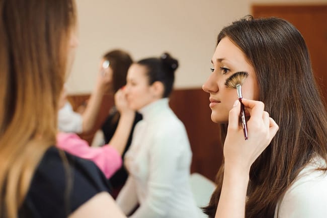 beauty students practice applying makeup on volunteers
