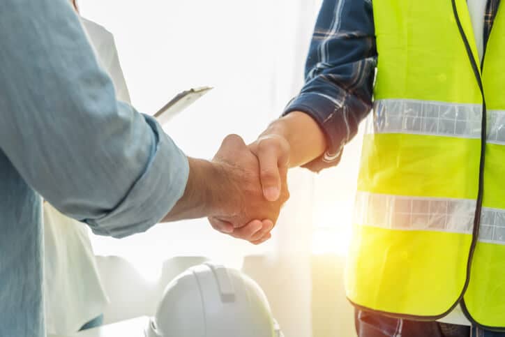 Construction worker shaking hands with an insurance advisor