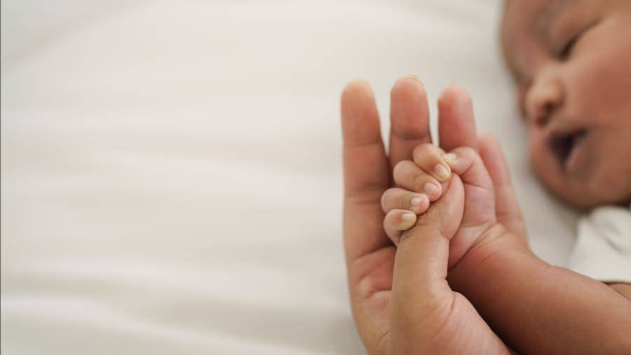 Newborn Baby Hand Holding Mom’s Finger