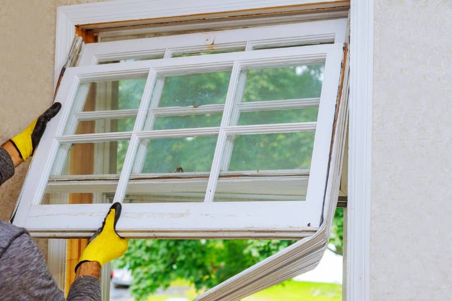 A man installs a replacement window