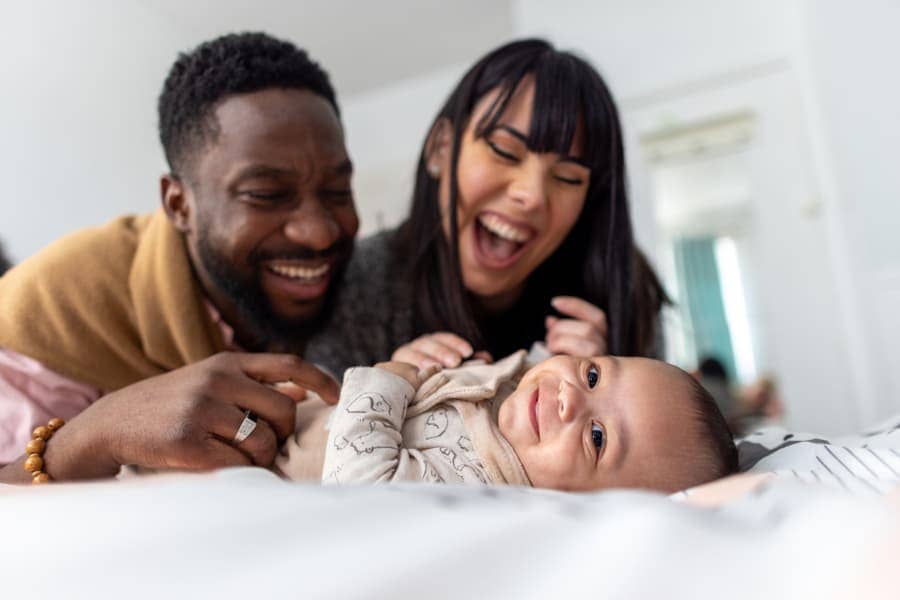 Happy parents playing with newborn