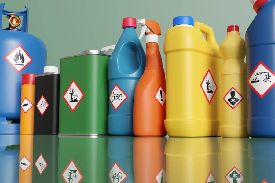 Plastic bottles and metallic tins with different hazardous warning labels