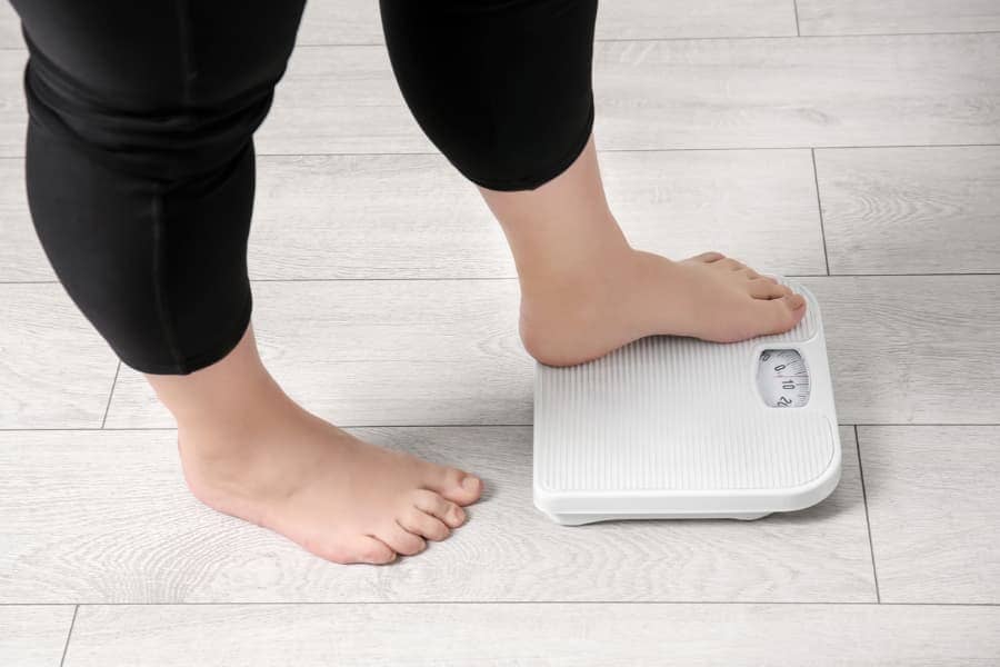 Woman Weighing Herself On Scale