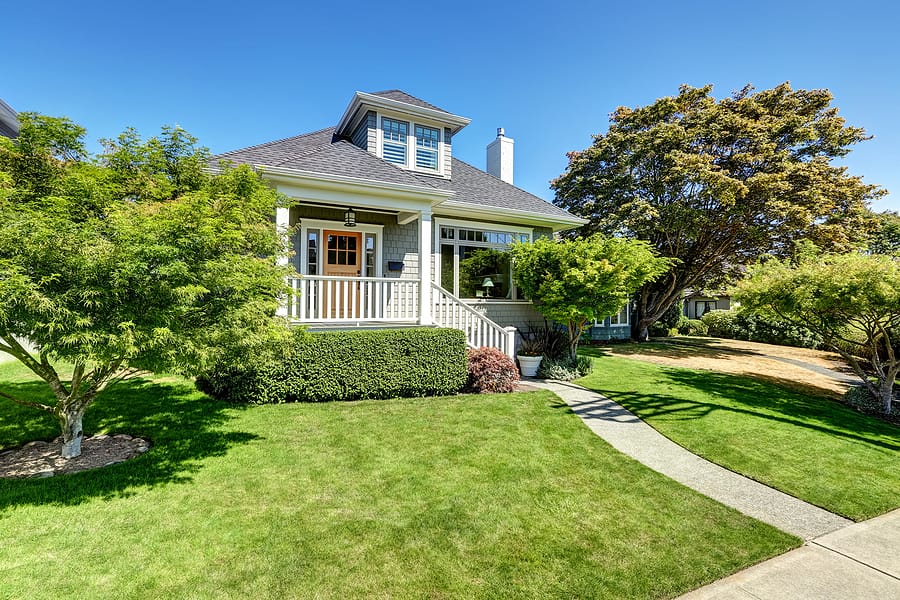 Single-family American craftsman house exterior. Blue sky background and nicely trimmed front yard. Northwest USA