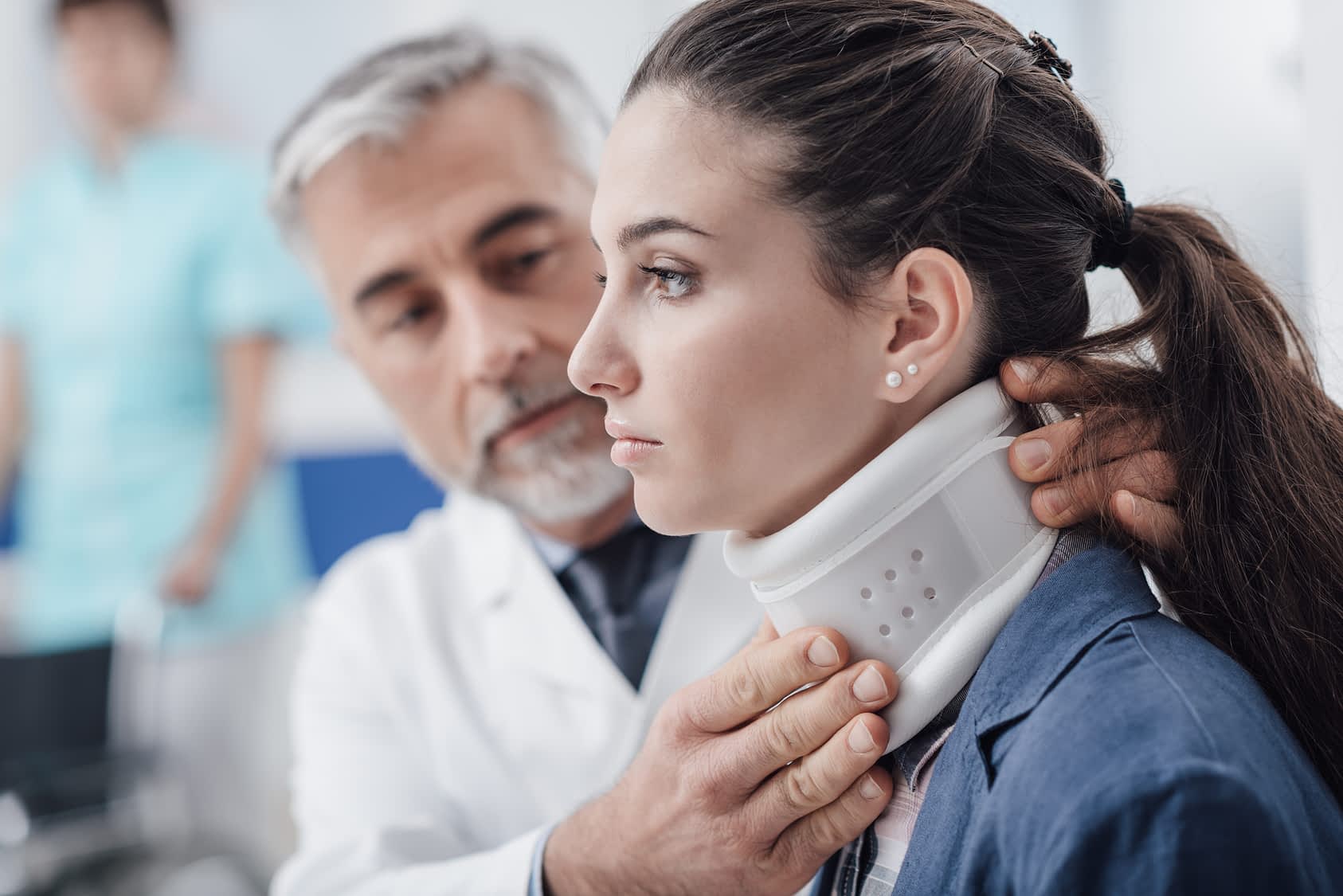 Doctor fitting patient with neck brace