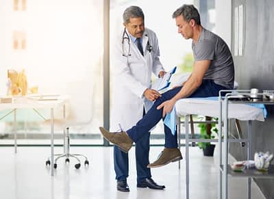 Doctor Evaluates Patient Knee Injury