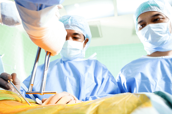 A doctor performing spine surgery on a patient.
