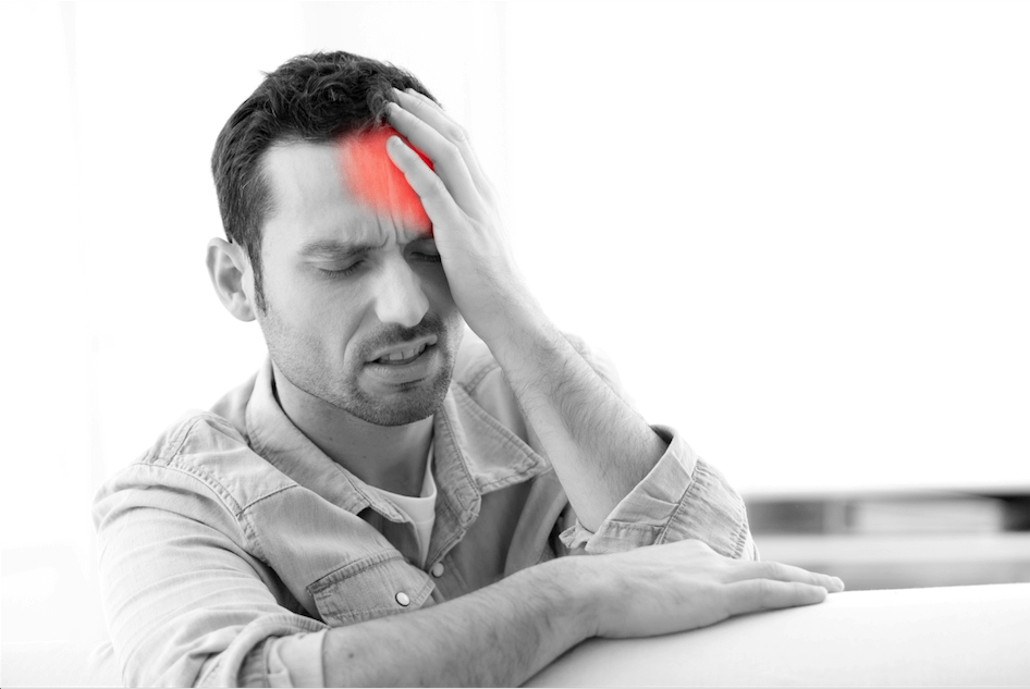 Man clutching reddened area of head representing headache